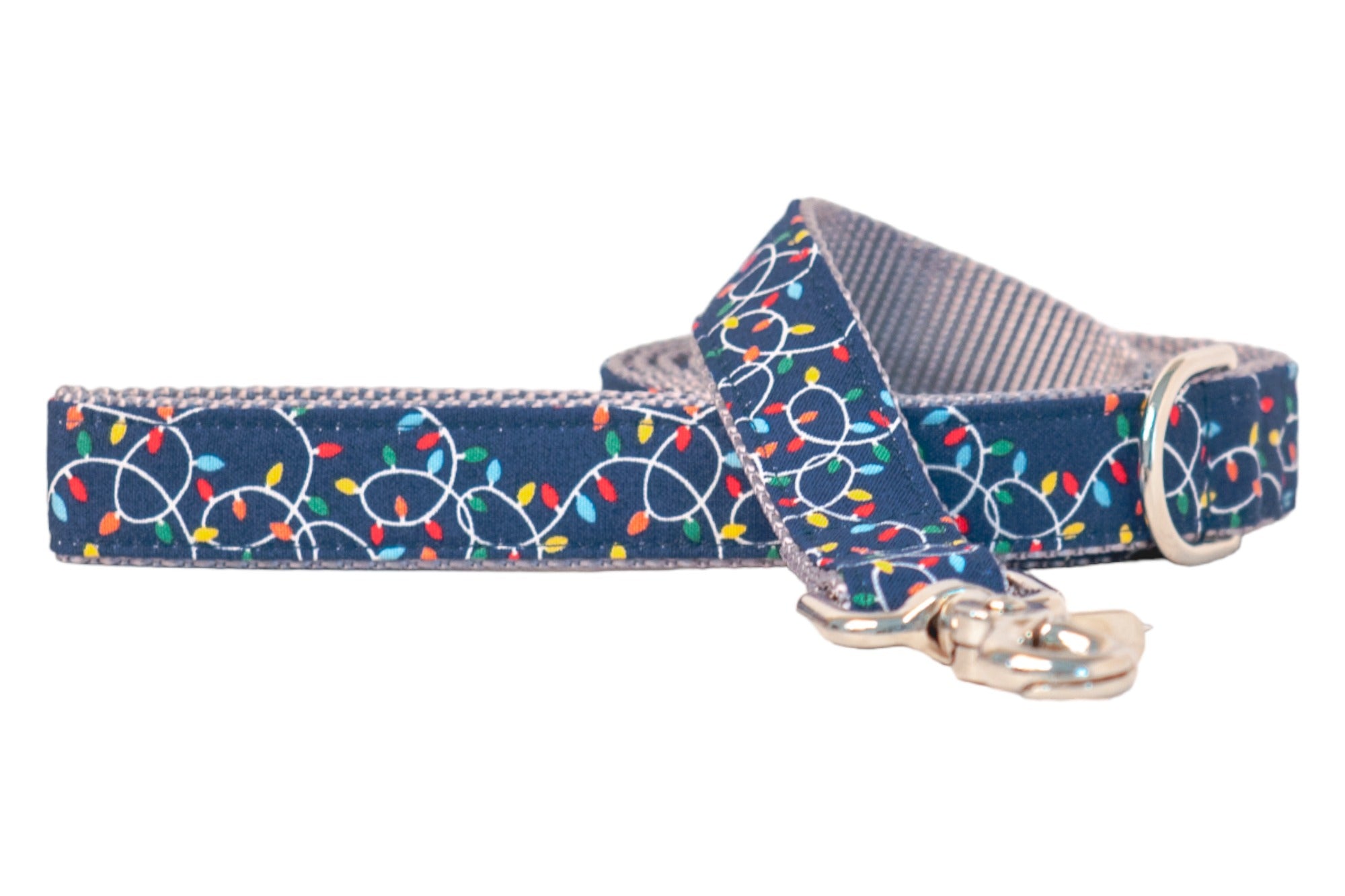 Navy blue dog leash with a playful holiday design of Christmas lights strung across in festive colors. The lights are connected with looping cords that pop against the dark background. Reinforced edges and polished hardware, including a swivel clasp, give it both durability and style.