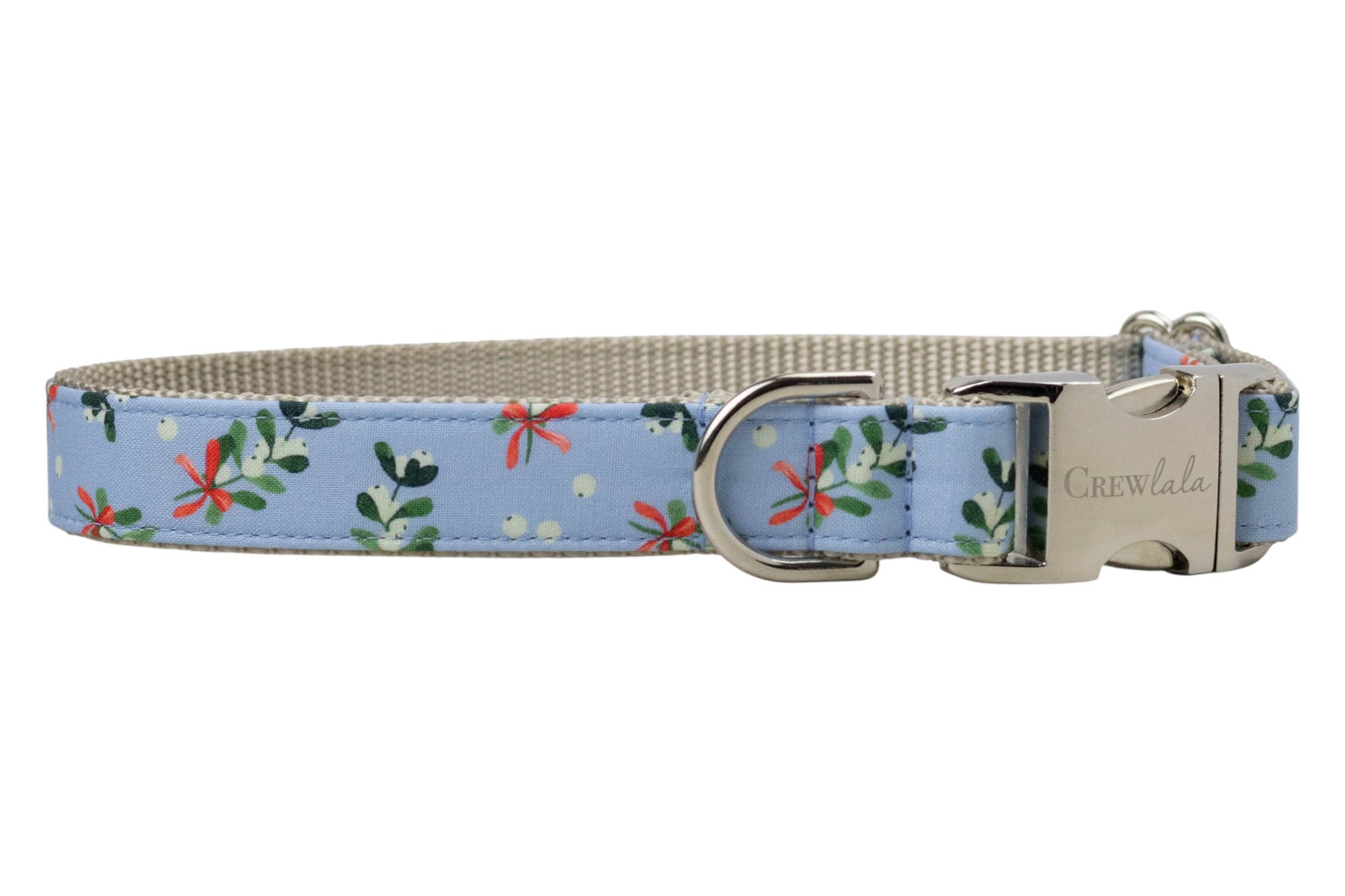 A festive dog collar featuring a light blue fabric adorned with mistletoe leaves, berries, and ribbon bows. The collar includes a sturdy webbing interior, a metal D-ring for accessory attachment, and a polished metal buckle engraved with the brand name "Crewlala."